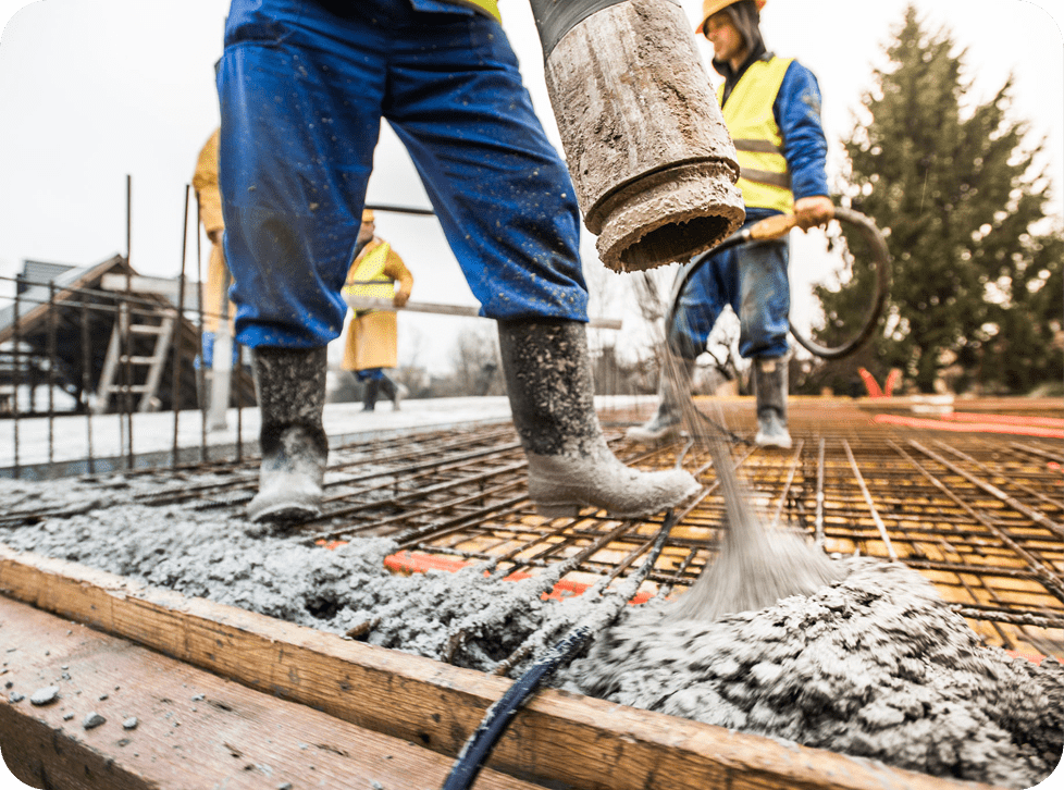 Construction workers pouring concrete on site.